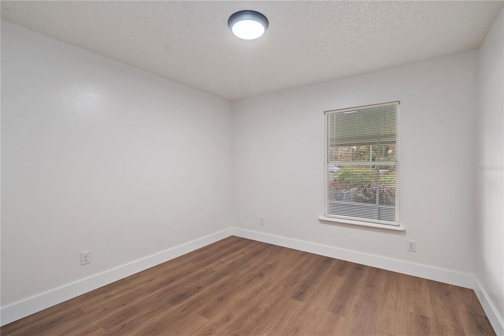 7670 Southwest 80th Place Ocala, FL 34476 - Photo 23 of 44 an empty room with wooden floor and windows
