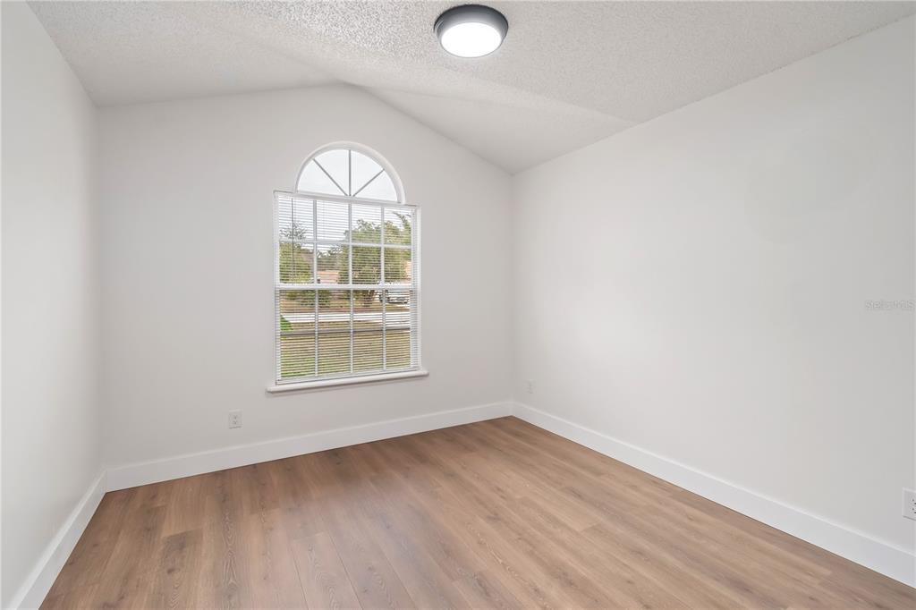 7670 Southwest 80th Place Ocala, FL 34476 - Photo 26 of 44 an empty room with wooden floor and windows