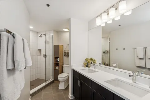 a bathroom with a granite countertop sink a toilet and shower