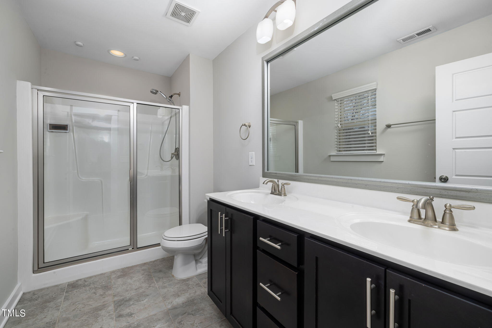7800 Allscott Way Raleigh, NC 27612 - Photo 23 of 29 a bathroom with a granite countertop sink a toilet a mirror and shower