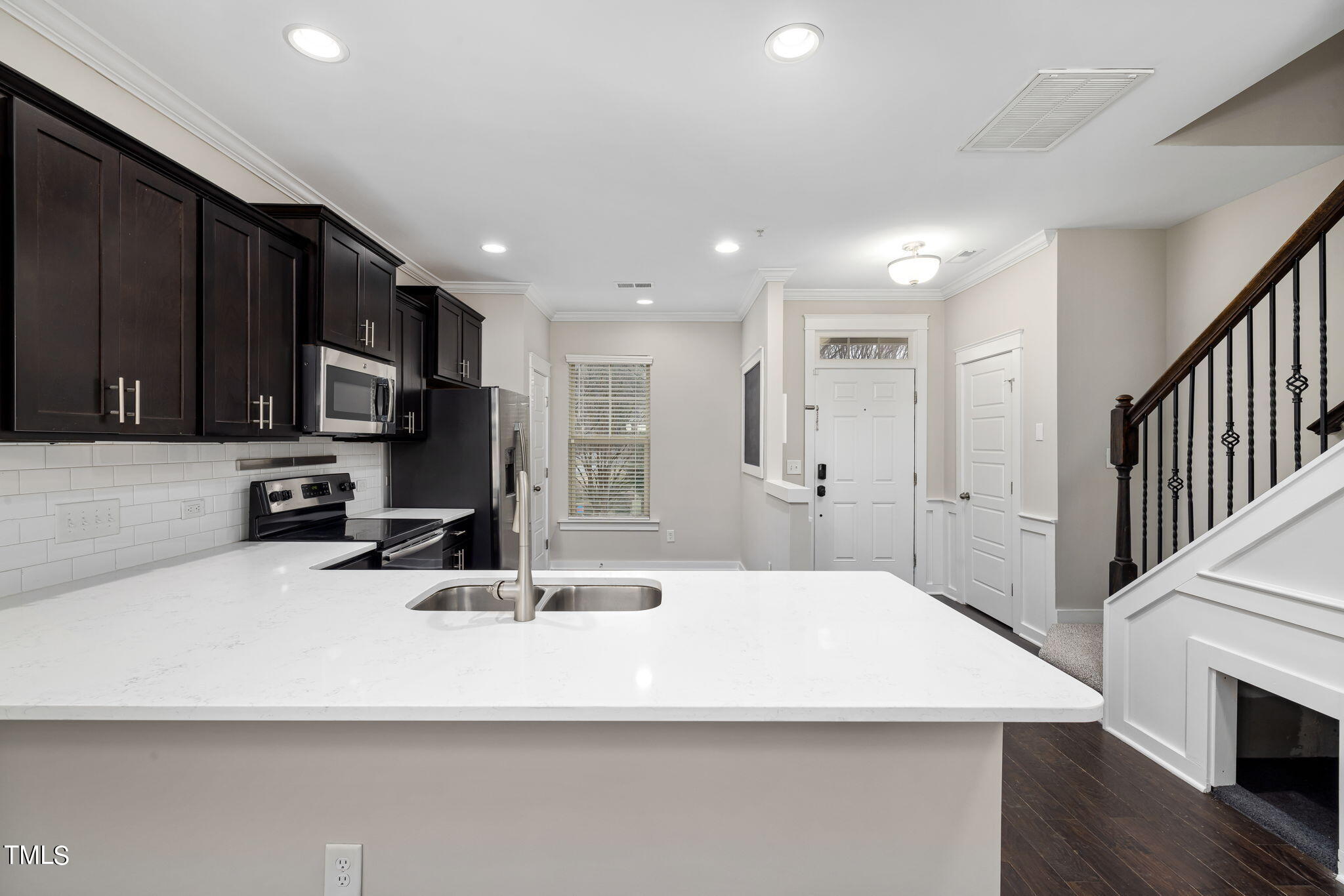 7800 Allscott Way Raleigh, NC 27612 - Photo 4 of 29 a kitchen with stainless steel appliances a sink a stove a microwave a center island and furniture