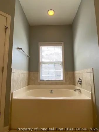 a bath tub sitting in a bathroom next to a window