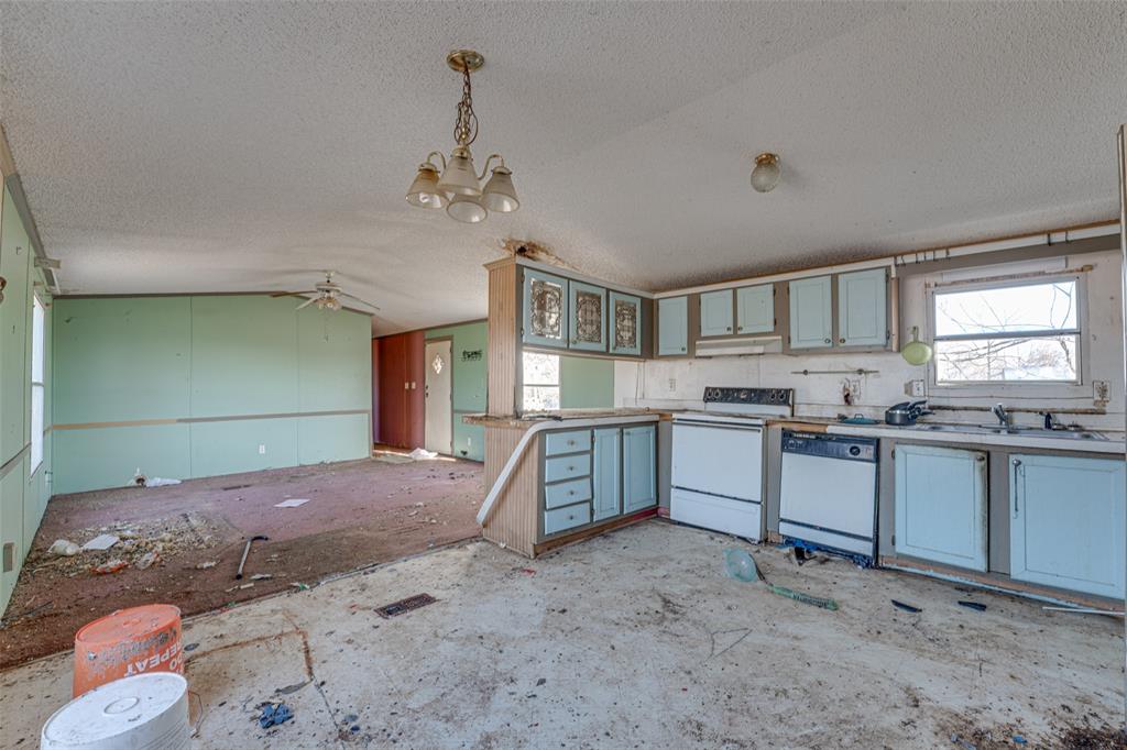 100 Zodiac Strait Road Ferris, TX 75125 - Photo 8 of 19 a kitchen with a refrigerator and a sink