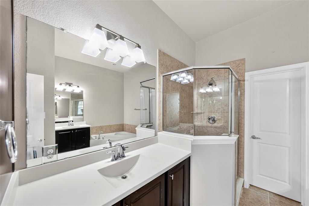 8607 Calvin Road Irving, TX 75063 - Photo 32 of 39 Spacious bathroom featuring a double vanity with white countertops, undermount sinks, and dark wood cabinetry
