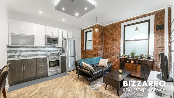 a living room with stainless steel appliances granite countertop furniture and a fireplace