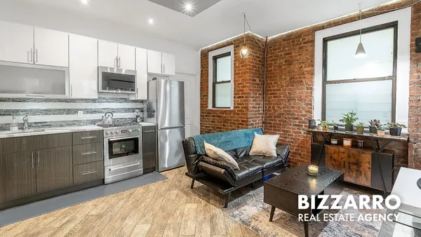 a kitchen with stainless steel appliances granite countertop a stove a sink dishwasher and a refrigerator with wooden floor