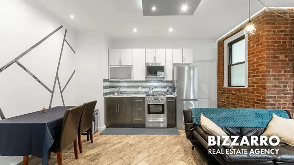 a kitchen with kitchen island a stove a refrigerator and a dining table with wooden floor