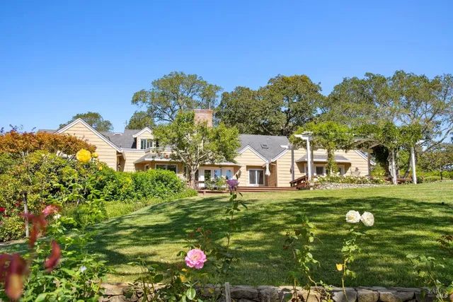 a front view of a house with a garden and plants