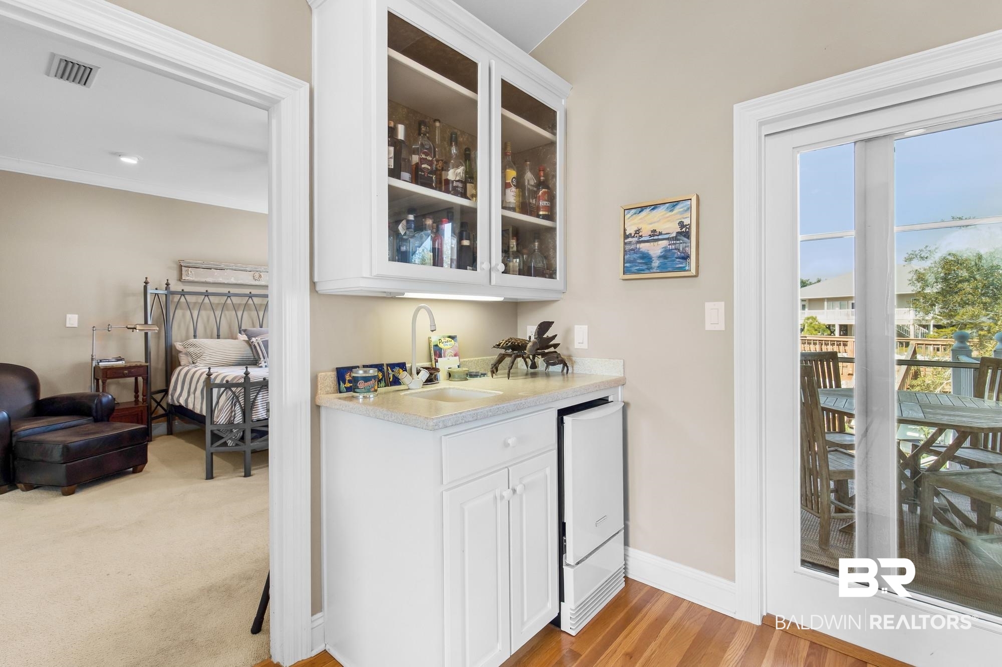32191 River Road Orange Beach, AL 36561 - Photo 11 of 46 Indoor wet bar featuring white cabinetry, glass fronted cabinets, light stone counters, light wood-style floors, and white refrigerator