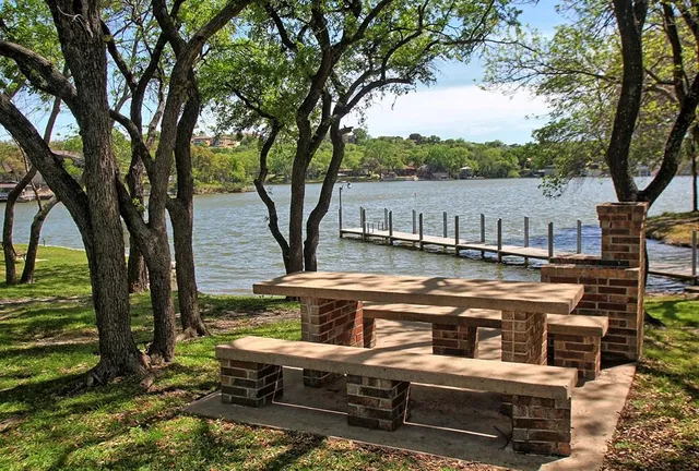 a view of a swimming pool with a patio and wooden fence