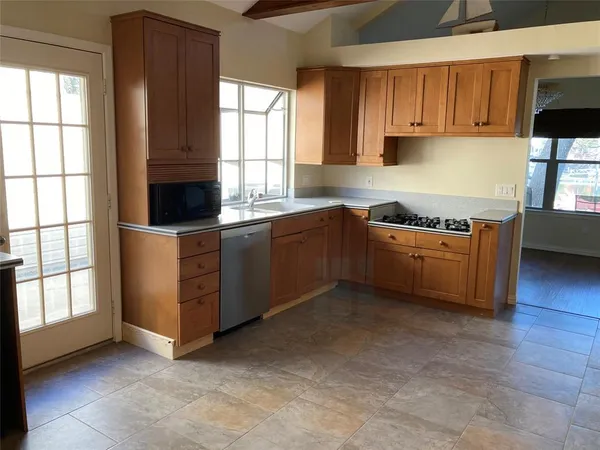 a kitchen with stainless steel appliances granite countertop a sink and a stove