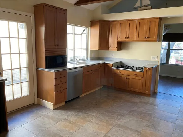 a kitchen with stainless steel appliances granite countertop a sink and a stove