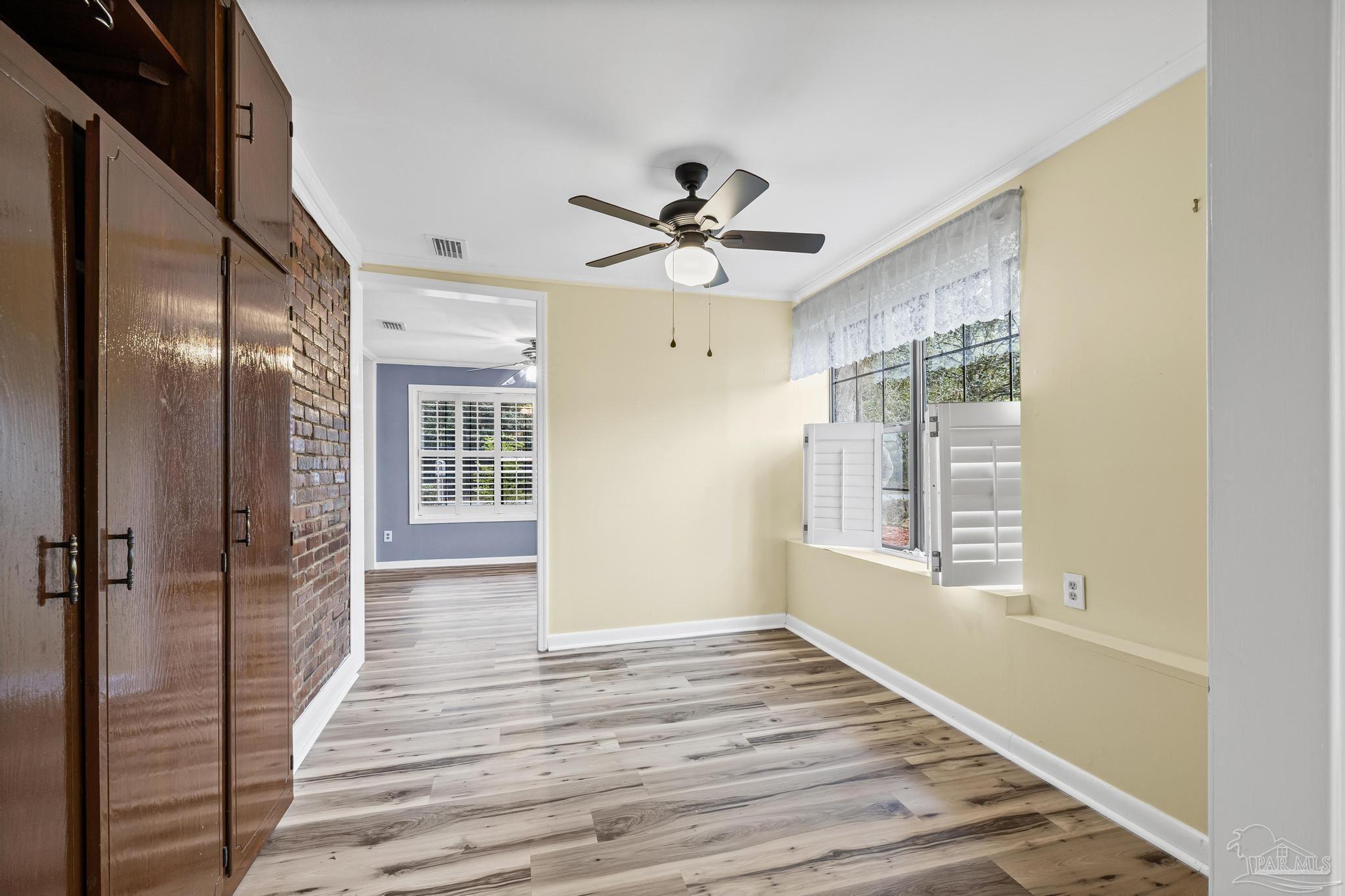3811 Wilkes Street Pace, FL 32571 - Photo 13 of 59 a view of an empty room with a window and wooden floor