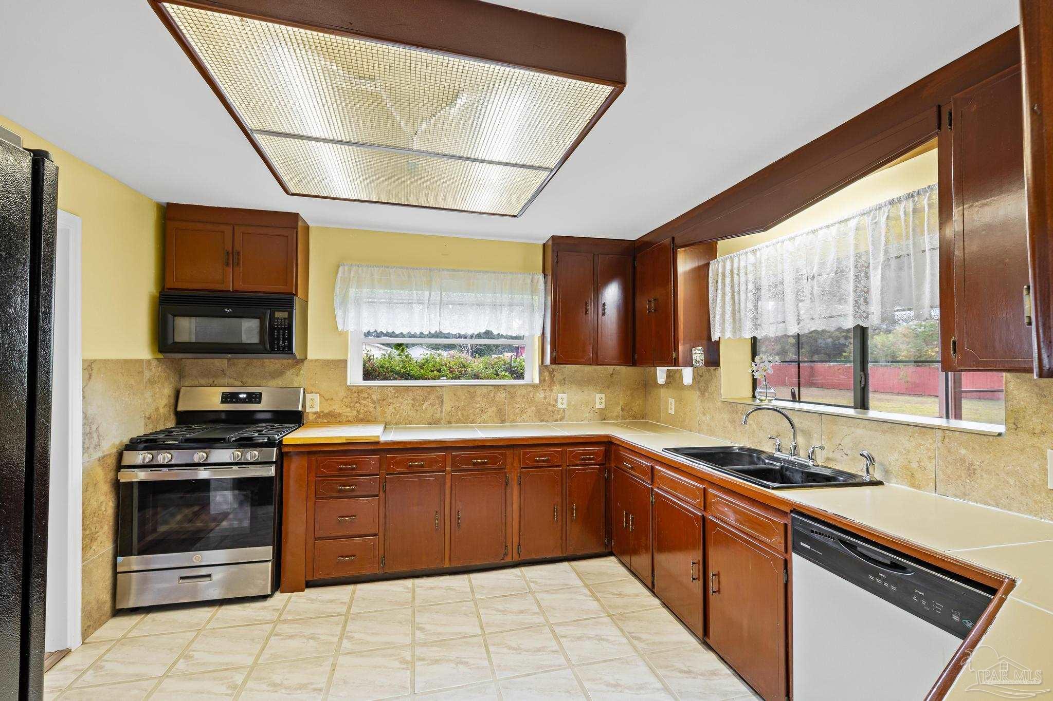 3811 Wilkes Street Pace, FL 32571 - Photo 19 of 59 a kitchen with stainless steel appliances a stove sink and microwave