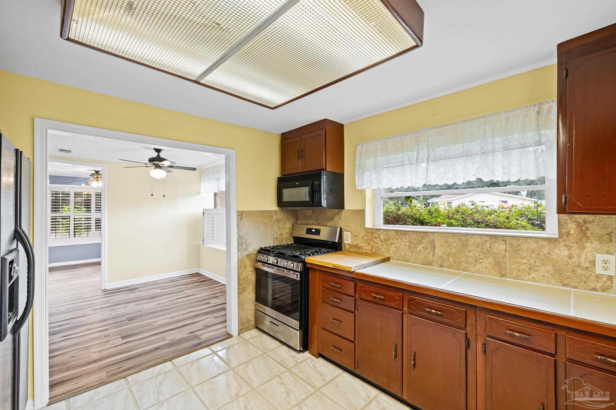 3811 Wilkes Street Pace, FL 32571 - Photo 20 of 59 a kitchen with stainless steel appliances granite countertop a stove a sink and a refrigerator