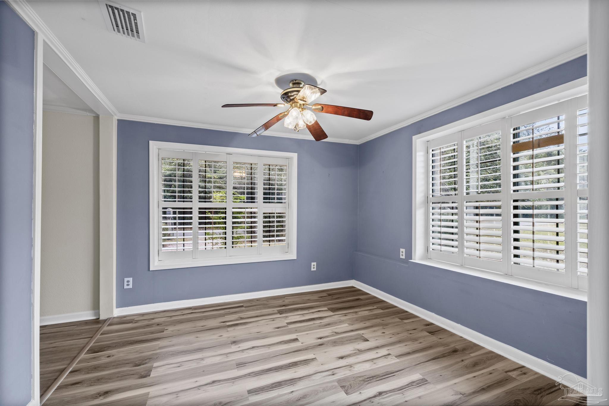 3811 Wilkes Street Pace, FL 32571 - Photo 22 of 59 a view of an empty room with a window and wooden floor