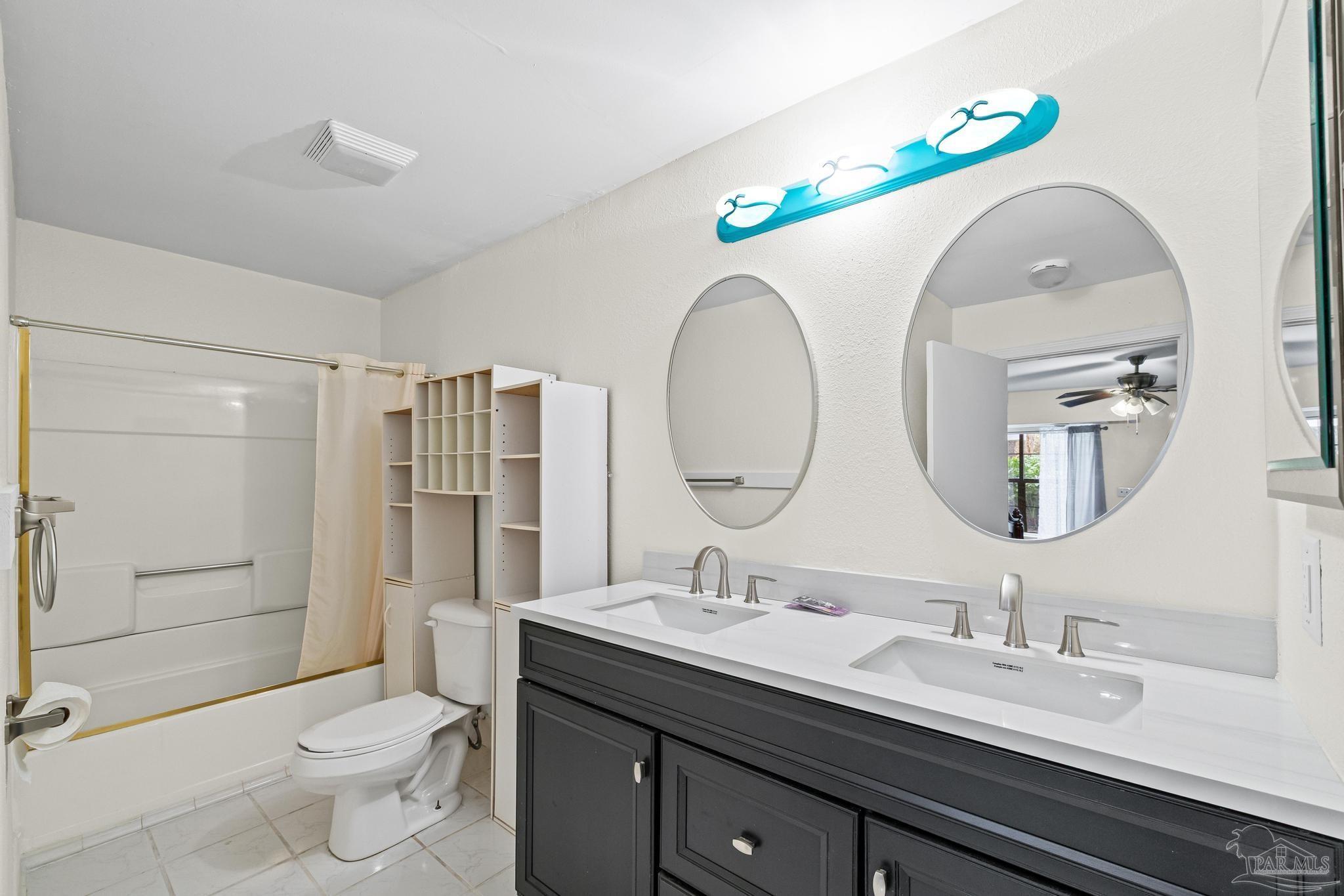 3811 Wilkes Street Pace, FL 32571 - Photo 35 of 59 a bathroom with a double vanity sink mirror and toilet