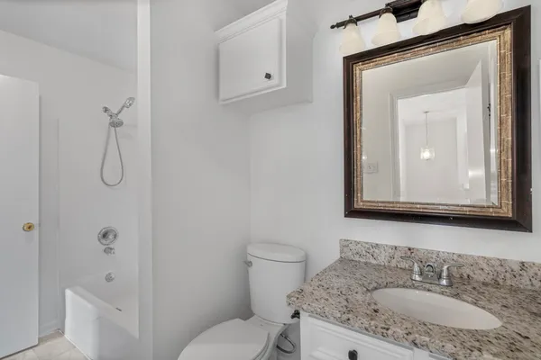 a bathroom with a granite countertop sink toilet and shower