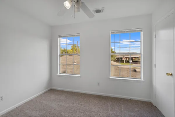 an empty room with windows and closet