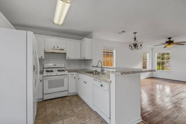 a kitchen with granite countertop a sink stainless steel appliances and cabinets