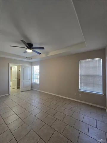 an empty room with windows and fan