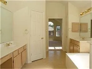 a bathroom with a tub sink and mirror