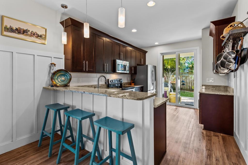 311 E Street St. Augustine, FL 32080 - Photo 10 of 39 a kitchen with stainless steel appliances kitchen island granite countertop a table chairs and a refrigerator