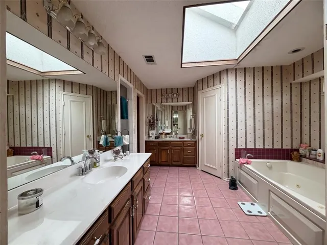a bathroom with a tub a sink and mirror