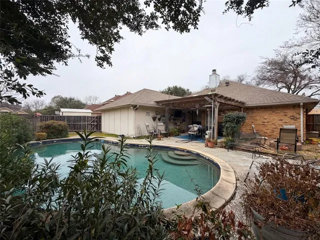 a view of a house with pool plants and large trees