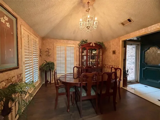 a view of a dining room with furniture and chandelier