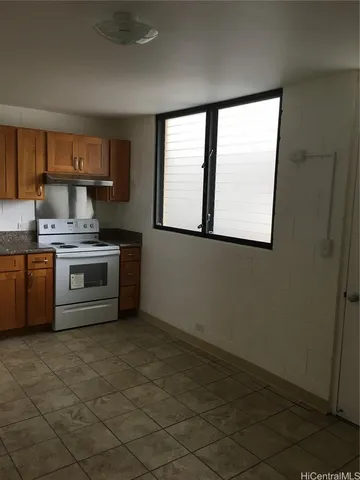 a kitchen with a stove a sink and a window