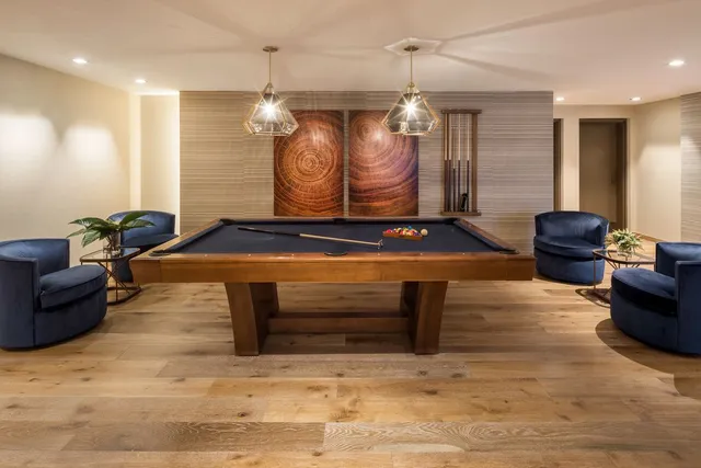 a room with furniture pool table and window