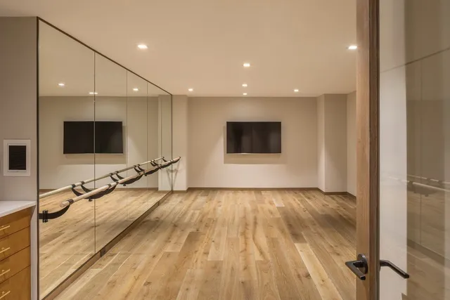 a view of a room with wooden floor and flat screen tv