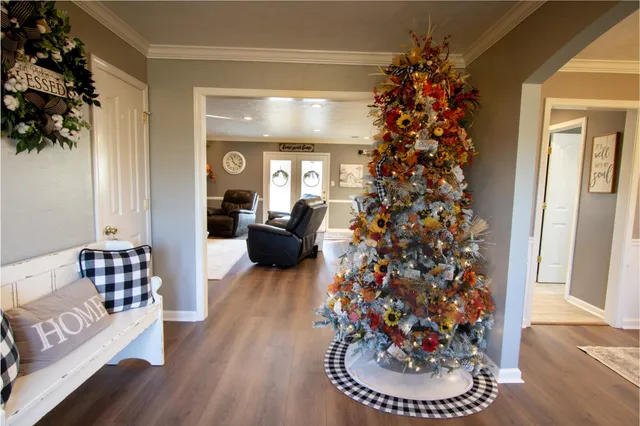 a dining room with wooden floor a chandelier a wooden table and chairs