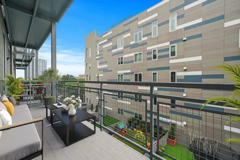 a view of a balcony with couches and potted plants