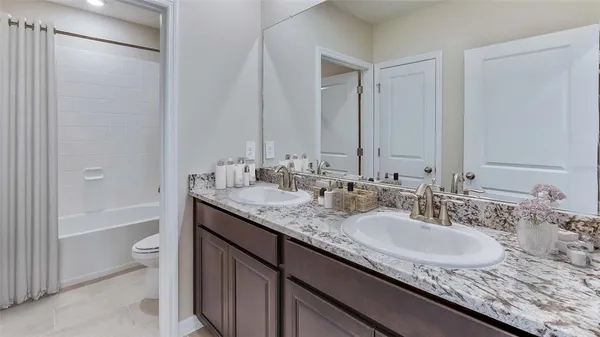 a bathroom with a granite countertop sink a toilet and shower
