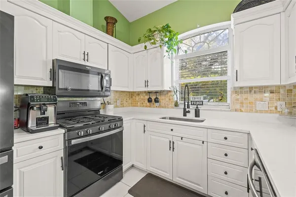 a dining room filled chandelier and kitchen view