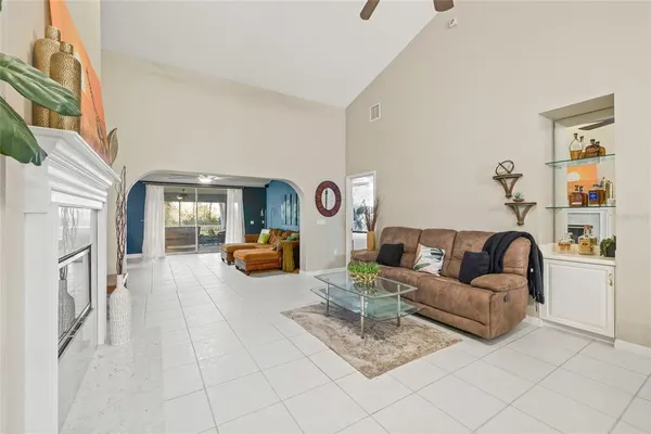 a living room with furniture a fireplace and a chandelier