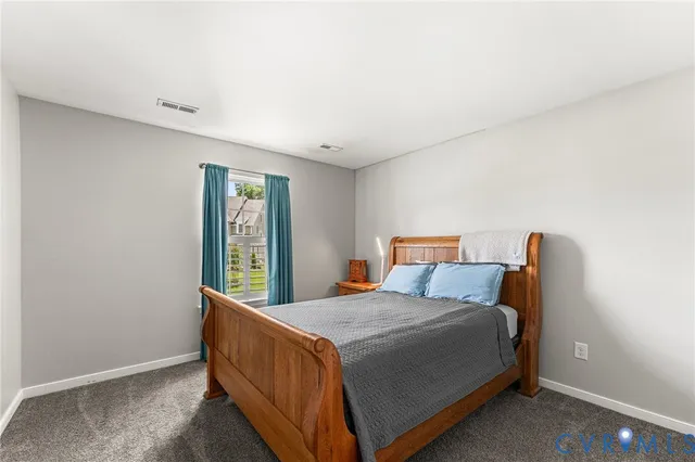 a bed sitting in a bedroom next to a window