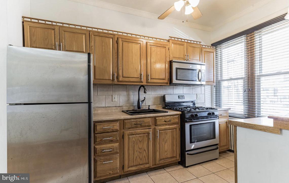 220 South 53rd Street Philadelphia, PA 19139 - Photo 4 of 15 a kitchen with stainless steel appliances granite countertop a refrigerator stove a sink dishwasher and microwave