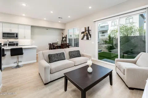 a living room with furniture a table and a large window