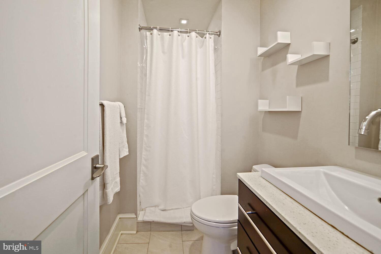 3348 Prospect Street Northwest, Unit 1 Washington, DC 20007 - Photo 11 of 16 a bathroom with a sink a toilet and shower