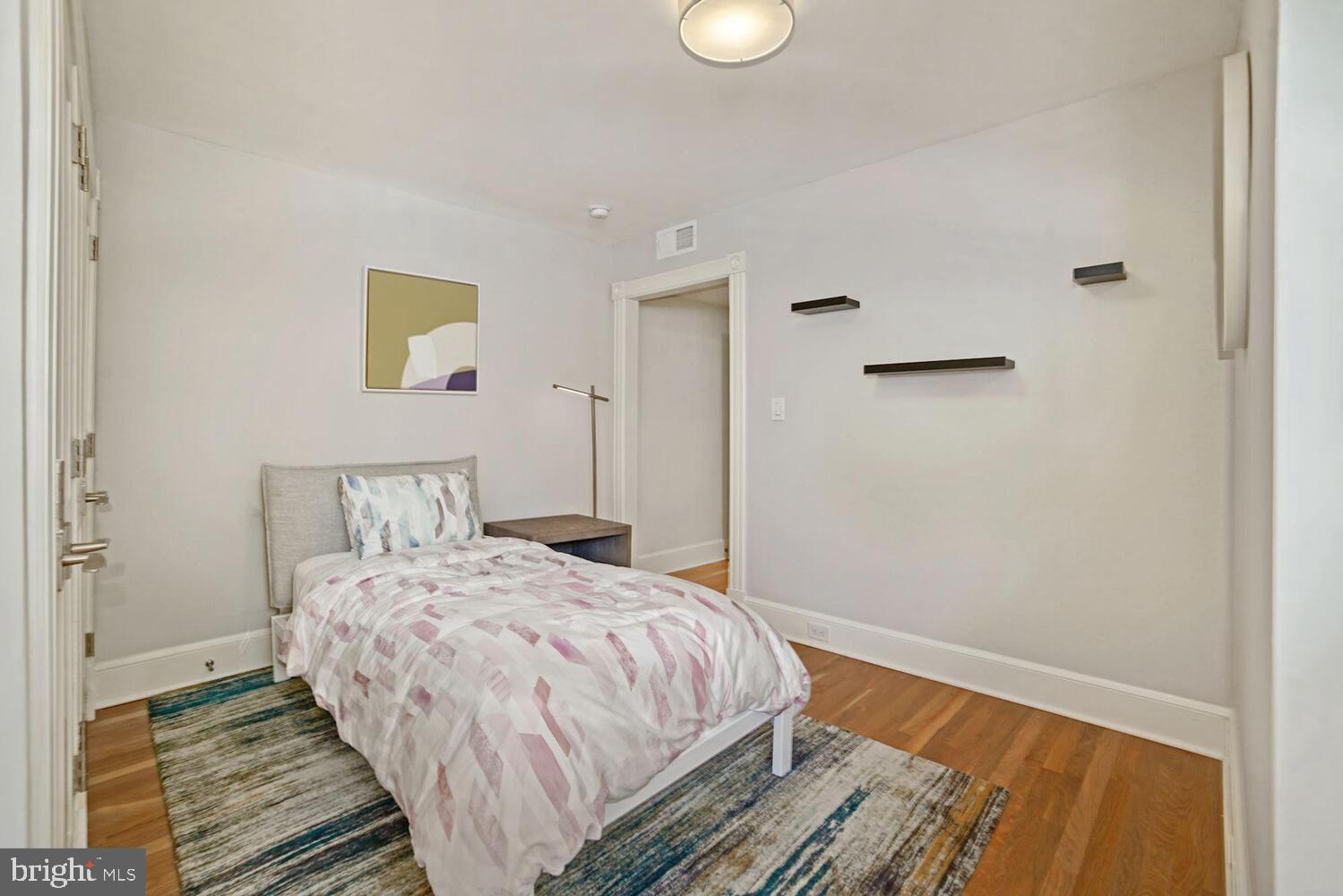 3348 Prospect Street Northwest, Unit 1 Washington, DC 20007 - Photo 8 of 16 a bedroom with a bed and painting on the wall