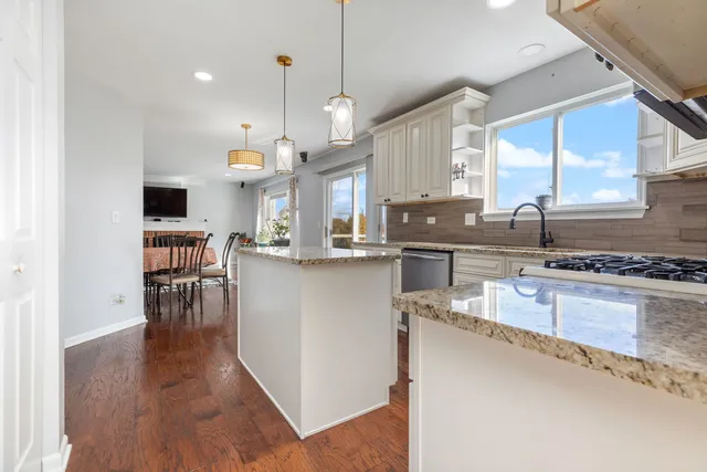 a kitchen with stainless steel appliances granite countertop a sink stove and wooden floor
