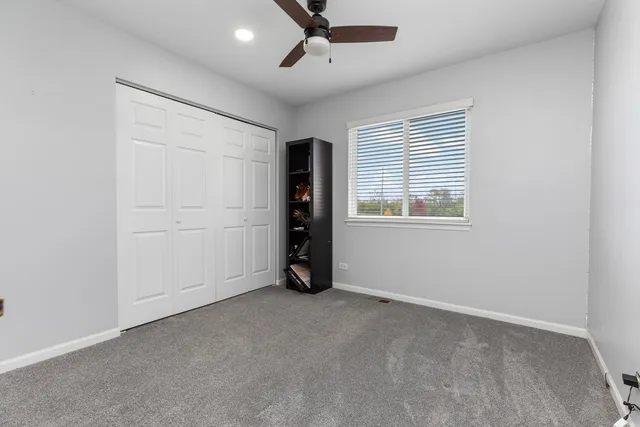 an empty room with a window and ceiling fan