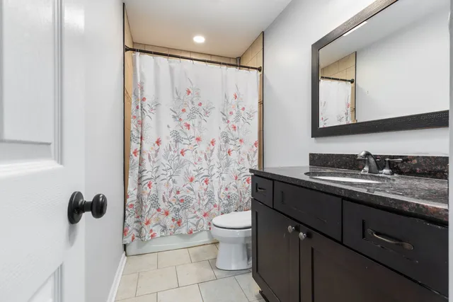 a bathroom with a granite countertop sink toilet and shower