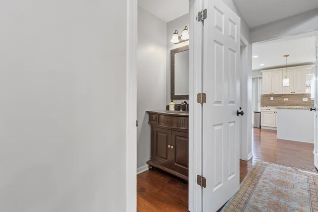 a view of a kitchen with refrigerator and wooden floor