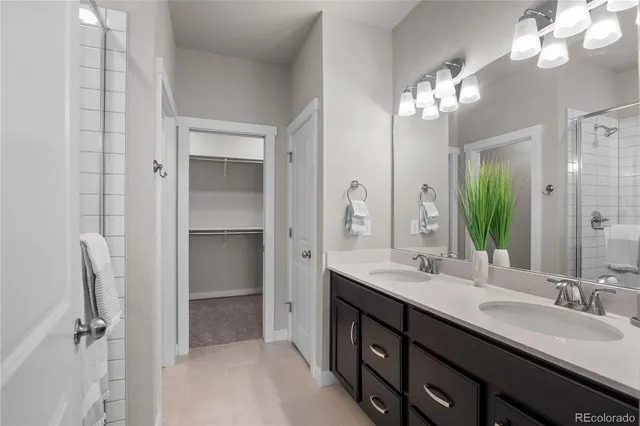 a bathroom with double vanity sinks a vanity a lamp and a mirror