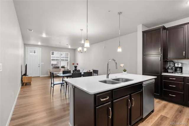 a kitchen with a sink appliances and wooden floor