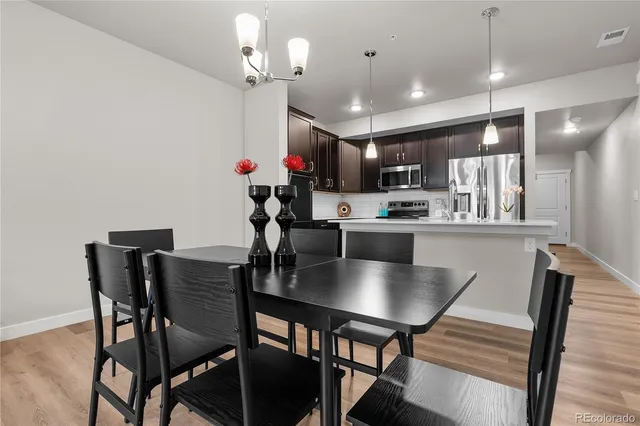 a kitchen with kitchen island a dining table and chairs